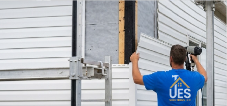 Handyman working on the siding of a building