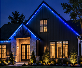 Permanent roofline lighting in blue on a dark modern home