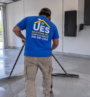 UES Solutions installer rolling epoxy base coat on a garage floor
