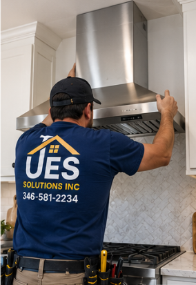 UES Solutions technician mounting a stainless chimney hood
